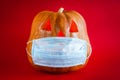 Halloween pumpkin in a protective medical mask on a red background Royalty Free Stock Photo