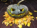 Halloween is the pumpkin. Halloween pumpkins decorated with pumpkin seeds placed on a wooden table.