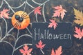 Halloween, pumpkin, spider, red maple leaves, spider web drawn in chalk on a dark rustic background. Signboard with with text-Hall Royalty Free Stock Photo