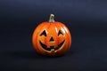 Halloween pumpkin standing on dark background