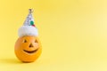 Halloween pumpkin wearing Santa Claus hat isolated on yellow. Royalty Free Stock Photo