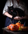 Halloween pumpkin and woman with furious black cat