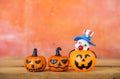 Halloween pumpkin and wooden Bozo ghost with space on orange cement wall