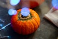 Halloween Pumpkins of bright orange color lie on a dark background, next to red berries. Royalty Free Stock Photo