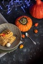 Halloween Pumpkins of bright orange color lie on a dark background, next to red berries. Royalty Free Stock Photo