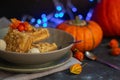 Halloween Pumpkins of bright orange color lie on a dark background, next to red berries. Royalty Free Stock Photo