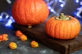 Halloween Pumpkins of bright orange color lie on a dark background, next to red berries. Royalty Free Stock Photo