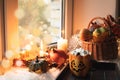 Halloween with pumpkins, coffee with marshmallow on windowsill. Stay at home in lockdown. Cozy still-life, furskin, garland