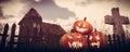 Halloween pumpkins in gothic scenery with hunted house and grave
