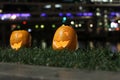 Halloween Pumpkins head. Orange pumpkin with a smile and eyes on night city and lights background Royalty Free Stock Photo