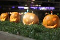 Halloween Pumpkins head. Orange pumpkin with a smile and eyes on night city and lights background Royalty Free Stock Photo