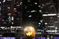 Halloween Pumpkins head. Orange pumpkin with a smile and eyes on night city and lights background Royalty Free Stock Photo