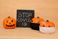 Halloween pumpkins in protective face masks and the inscription stop covid 19 Royalty Free Stock Photo