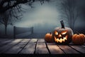 Halloween pumpkins on wooden planks with foggy background, One spooky halloween pumpkin, Jack O Lantern, with an evil face and Royalty Free Stock Photo