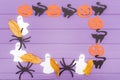 Halloween round frame with different paper silhouettes of pumpkins, cats, ghosts and spiders with autumn leaves