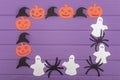 Halloween round frame with different paper silhouettes of pumpkins, hats, ghosts and spiders