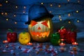 Halloween`s Eve. Jack-o-lantern in a hat and candles inside, scaring face lights isolated night dark background blue grightening Royalty Free Stock Photo