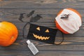Halloween scary face mask, pumpkin, disinfection gel bottle, bat and spider decoration top view