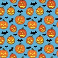 Halloween seamless pattern with orange pumpkins carved faces and black bats on blue background Royalty Free Stock Photo