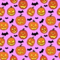 Halloween seamless pattern with orange pumpkins carved faces and black bats on pink background Royalty Free Stock Photo