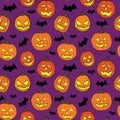 Halloween seamless pattern with orange pumpkins carved faces and black bats on violet background Royalty Free Stock Photo