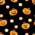 Halloween seamless pattern. Scary pumpkins, orange and yellow sweet candies on  dark background. Royalty Free Stock Photo