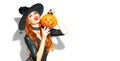 Halloween. witch with bright holiday makeup. Beautiful young woman posing in witches costume with pumpkin lantern Royalty Free Stock Photo