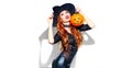 Halloween. witch with bright holiday makeup. Beautiful young woman posing in witches costume with pumpkin lantern Royalty Free Stock Photo