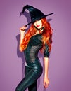 Halloween. witch with bright makeup and long red hair. Beautiful young woman posing in witches costume Royalty Free Stock Photo