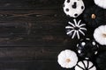 Halloween side border of black and white patterned pumpkins on a black wood background