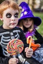 Halloween. Skeleton and witch holding colorful candies Royalty Free Stock Photo