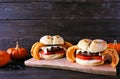 Halloween spider hamburgers with onion ring legs against dark wood