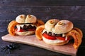 Halloween spider hamburgers with onion ring legs against dark wood