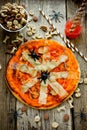 Halloween Spider Pizza with tomato sauce and cheese on a wooden