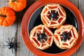 Halloween spider web mini pizzas on black and orange plate