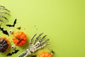 Halloween spooky decorations concept. Top view photo of skeleton hands holding eyeball pumpkins bat silhouettes insects spiders Royalty Free Stock Photo