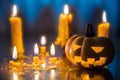 Halloween spooky Jack-O-Lantern pumpkin head with candles decoration at night background, selective focus