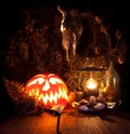 Halloween still life. Scary Halloween pumpkin, mushroom, candles, dried herbs, ferns and the skull of a dead animal with