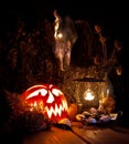 Halloween still life. Scary Halloween pumpkin, mushroom, candles, dried herbs, ferns and the skull of a dead animal with