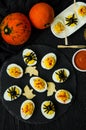 Halloween stuffed eggs with cheese and mustard on a black stone. Royalty Free Stock Photo