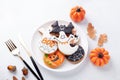 Halloween table setting with gingerbread cookies on white plate and cuterly on white background. Bright homemade cookies Royalty Free Stock Photo