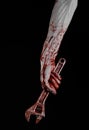 Halloween theme: bloody hand holding a big wrench on a black background Royalty Free Stock Photo