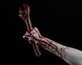 Halloween theme: bloody hand holding a big wrench on a black background Royalty Free Stock Photo