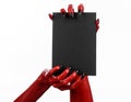 Halloween theme: Red devil hand with black nails holding a blank black card on a white background Royalty Free Stock Photo