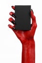 Halloween theme: Red devil hand with black nails holding a blank black card on a white background Royalty Free Stock Photo