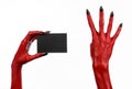 Halloween theme: Red devil hand with black nails holding a blank black card on a white background Royalty Free Stock Photo