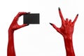 Halloween theme: Red devil hand with black nails holding a blank black card on a white background Royalty Free Stock Photo