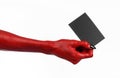 Halloween theme: Red devil hand with black nails holding a blank black card on a white background Royalty Free Stock Photo