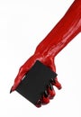 Halloween theme: Red devil hand with black nails holding a blank black card on a white background Royalty Free Stock Photo