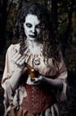 Halloween theme: ugly dread voodoo witch with mortar and pestle. Portrait of evil hex in dark forest. Zombie woman undead Royalty Free Stock Photo